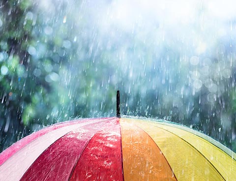 Rain falling on a colourful umbrella